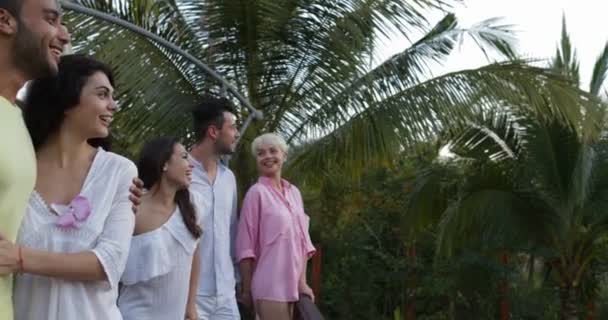 Emocionado grupo de personas mirando el atardecer sobre el bosque tropical en la terraza de verano en el hotel, mezclar amigos de carreras de vacaciones juntos — Vídeo de stock