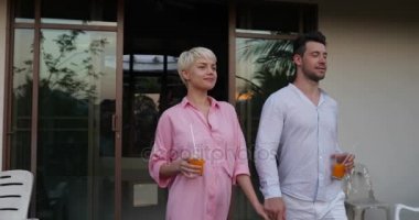 Adam ve kadın açık havada güzel günbatımı peyzaj üzerinde mutlu konuşurken el ele tutuşarak terasta genç çift çekip