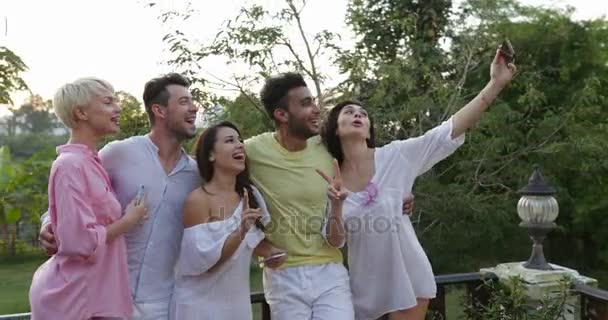 Grupo de personas tomando foto selfie en la terraza al atardecer, amigos posando para autorretrato al aire libre — Vídeos de Stock