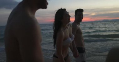 Grup yürüyüş günbatımı Pov, plaj, yaz deniz tatil mutlu saçak üzerinde konuşurken neşeli insan