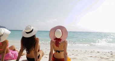 Arka arka üç kız plajda Bikini ve hasır şapkalar keyfini güneş Tan konuşurken, kadın turistlerin yaz tatil