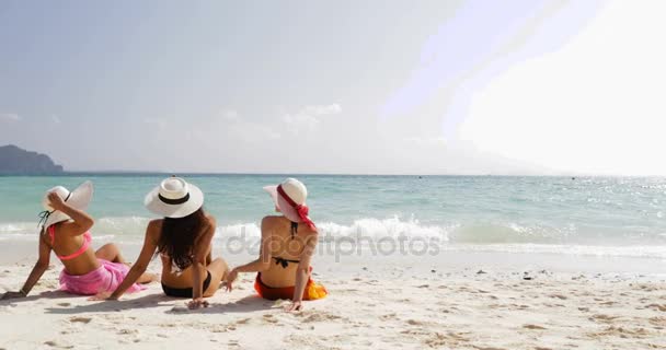 Rückansicht von drei Mädchen am Strand in Bikini und Strohhüten genießen Sonnenbräune im Gespräch, Touristinnen im Sommerurlaub — Stockvideo