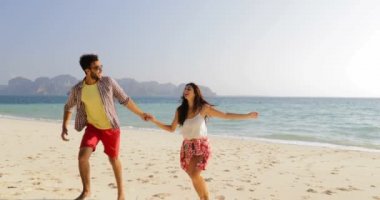 Adam önde gelen kadın su tutan eller kumsalda, çalıştırmak çift mutlu gülümseyen turist kucaklamak.