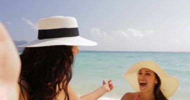 Kız hücrede akıllı telefon hoş geldiniz kadınlar Plajı, yaz tatili üzerinde hasır şapka neşeli turistler Selfie fotoğraf çekmek için