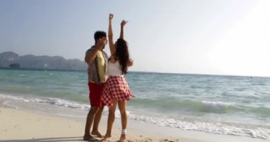 Mutlu çift el ele tutuşarak, genç adam ve kadın romantik tatil kucaklayan Beach üzerinde