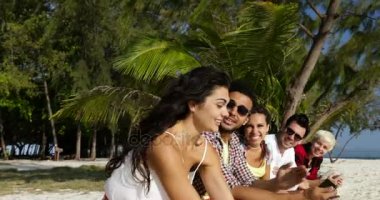 Palmiye ağaçları altında açık havada oturup sohbet, online sohbet insanlar Grup iletişim kullanarak akıllı telefonlar