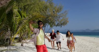 İspanyol adam arama insanlar grup akıllı telefonda Beach erkek ve kadın turist iletişim Selfie fotoğraf almak