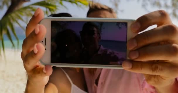 Coppia scattare foto selfie su cellulare Smart Phone sulla spiaggia baciare, felice sorridente uomo e donna Toursits in amore in vacanza — Video Stock