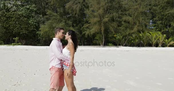 Paar am Strand umarmt sich küssend, junger Mann und verliebte Frau glückliche Touristen im Sommerurlaub — Stockvideo