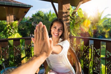 Jest POV yüksek beş adam neşeli kız için sabah elinde veren kadın yaz terasında masada otururken