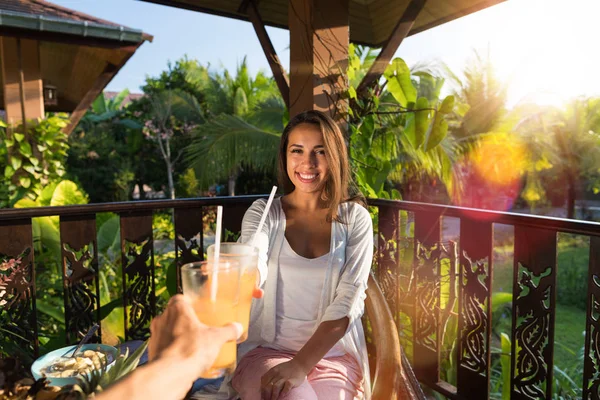 Coppia avendo colazione insieme bere succo tostatura punto di vista di uomo con felice sorridente giovane donna mangiare al mattino su terrazza — Foto Stock