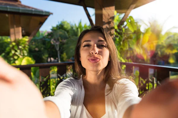 Pretty Woman dmuchanie pocałunek biorąc selfie zdjęcie młoda dziewczyna zrobić autoportret na zewnątrz — Zdjęcie stockowe