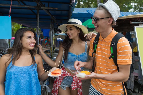 Groupe joyeux d'amis manger des fruits frais explorer la ville asiatique et les cafés de rue touristes jeunes heureux en vacances — Photo