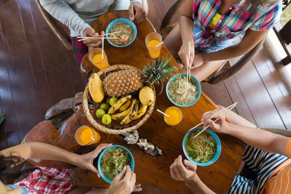 Vista de ángulo superior de la gente comiendo fideos asiáticos sopa comida tradicional — Foto de Stock