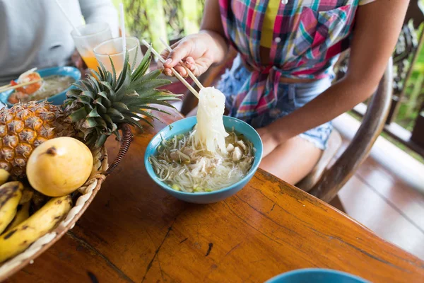 Geleneksel Asya gıda kadın yemek erişte yemek çubuğu tanınmayan insanlar çalışan en iyi açılı görünüş