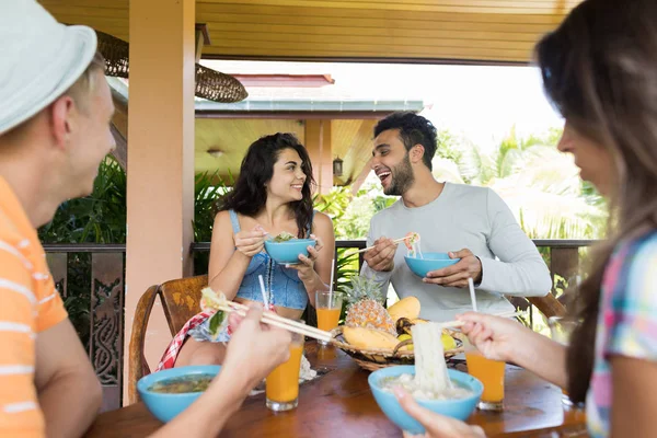 Ludzie jadalnia jedzenie razem azjatyckie makaron z pałeczkami szczęśliwy uśmiechający się młodych mężczyzn i kobiety cieszyć Asia tradycyjne danie — Zdjęcie stockowe