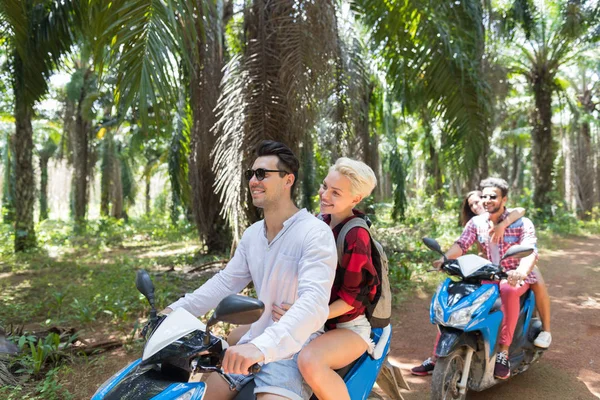 Tatil maceraya: İki Genç çiftler Scooter seyahat tropikal ormanda Bisiklet mutlu grup insan yapımı bir yolculuk üzerinde birlikte