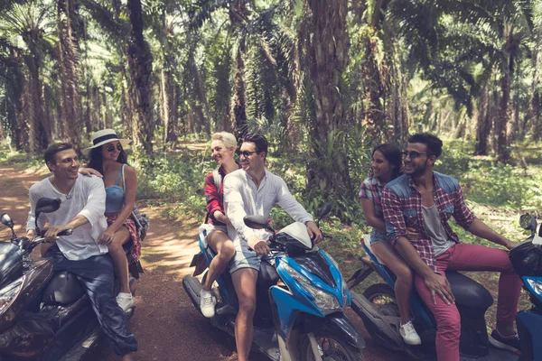 Junge Gruppe von Motorrollerfahrern reist im tropischen Wald fröhliche Freunde haben Roadtrip auf Fahrrädern — Stockfoto