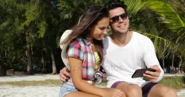 Açık havada kucaklayan palmiye ağaçları, gülümseyen adam ve kadın güneş keyfini mutlu çift oturmak