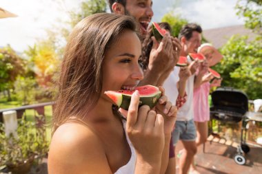 Neşeli grup arkadaşıyla eğlenmek insanların yeme karpuz birlikte mutlu gülümseyerek yan görünüm