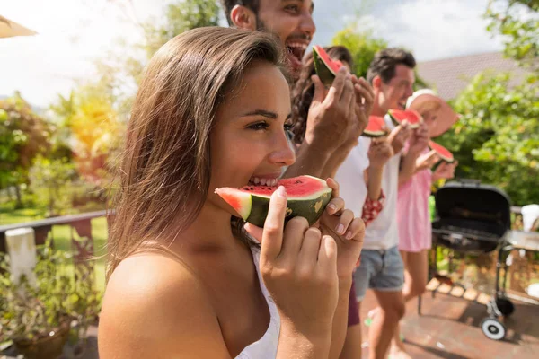 Neşeli grup arkadaşıyla eğlenmek insanların yeme karpuz birlikte mutlu gülümseyerek yan görünüm