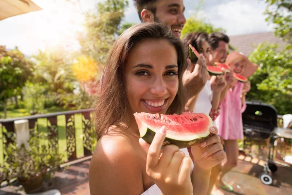 Karpuz dilimi gülümseme ile birlikte yaz terasında karpuz yeme arkadaş grubu ile neşeli kadın
