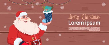 Mutlu Noeller ve mutlu yeni yıl tebrik kartı Noel Baba hediyesi Holding ile çorap kış tatil afiş kavramı