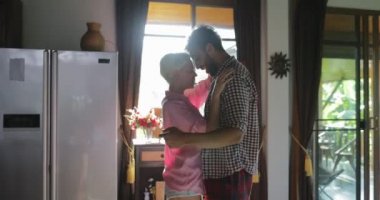 Portakal suyu, genç mutlu bir adam ve kadın sabah iletişim Modern Daire dans mutfakta kucaklayan çift içecek