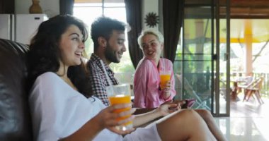 İnsanlar Tablet bilgisayar suyu, genç adam ve kadın grup Modern Daire iç konuşmaya sabah iç oturma odasında Tv izlerken Koç kullanın