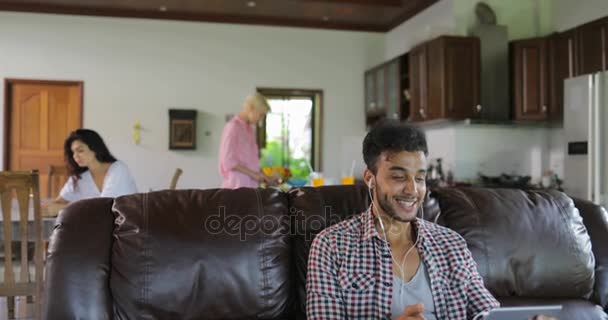 Man Make Online Video Call Usando Tablet Computador Sente-se no treinador na sala de estar, Latina Guy Falando Comunicação Internet — Vídeo de Stock