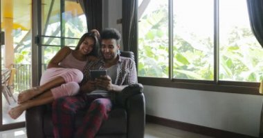 Ekran tarama Online Internet, genç çift evde birlikte kadın ve koltuk kullanan Tablet bilgisayarda, dokunmatik konuşurken oturan adam