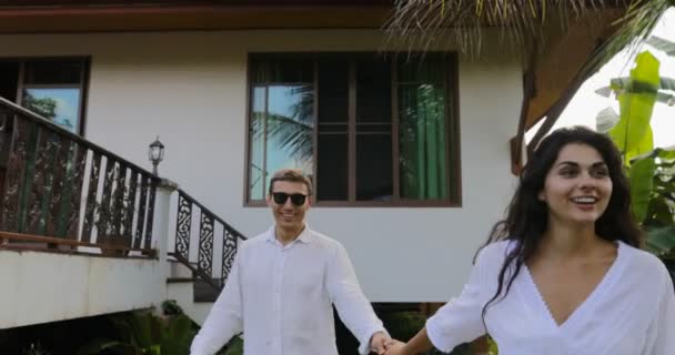 Woman Leading Man Walking In Tropical Garden Near Villa House, Happy Couple Outdoors Lovers On Vacation — Stok Video