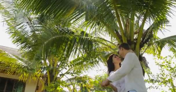 Koppel dansen onder palmboom In tropische tuin in de buurt van Villa huis, gelukkig Man en vrouw buitenshuis liefhebbers op vakantie — Stockvideo