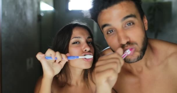 Casal escovando os dentes no banheiro, homem alegre e mulher feliz sorrindo dançando fazendo higiene da manhã — Vídeo de Stock