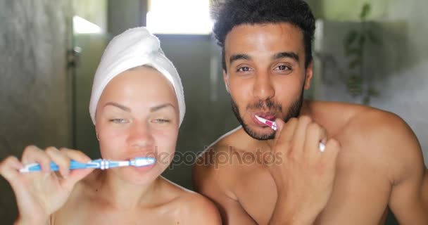 Paar tandenpoetsen In de badkamer, vrolijke Man en vrouw gelukkig lachend ochtend hygiëne doen praten — Stockvideo