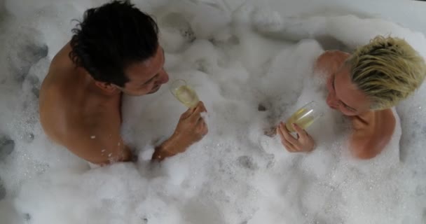 Молодая пара в ванной вместе пить шампанское Говоря Вид сверху угла, мужчина и женщина любовник наслаждаться спа дома — стоковое видео