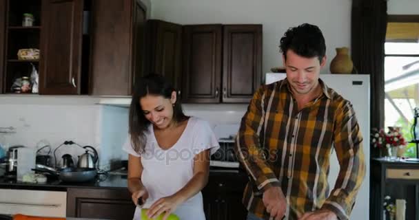 Paar kocht gemeinsam in der Küche, Frau und Mann reden über geschnittenes Gemüse, um ein gesundes Abendessen zuzubereiten — Stockvideo
