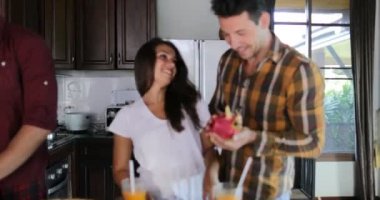 İki çiftler birlikte mutfak pişirme, genç kadın ve adam kesme sebze ve meyve grubu sağlıklı yemek hazırlamak