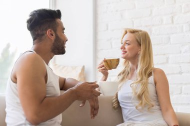 Koç yakınındaki pencere, genç güzel çift oturup içki sabah kahve fincanı, mutlu gülümseme Hispanik erkek ve kadın