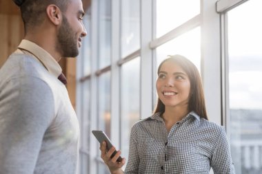 Yarış iş adam kadını kullanarak hücre akıllı telefon tribünde panoramik pencereden mutlu gülümseyen iş adamları mix