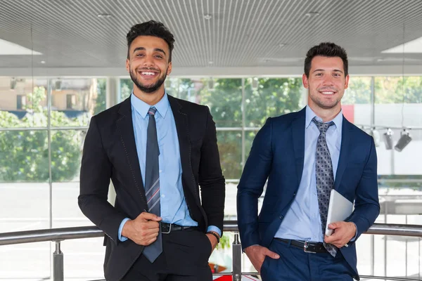 Dos hombres de negocios feliz sonrisa de pie en la oficina moderna —  Fotos de Stock
