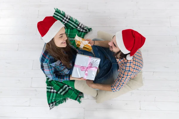 Adam vermek mevcut hediye kutusu kadın Noel tatil mutlu çift giymek katta oturan yeni yıl Santa şapka kap — Stok fotoğraf