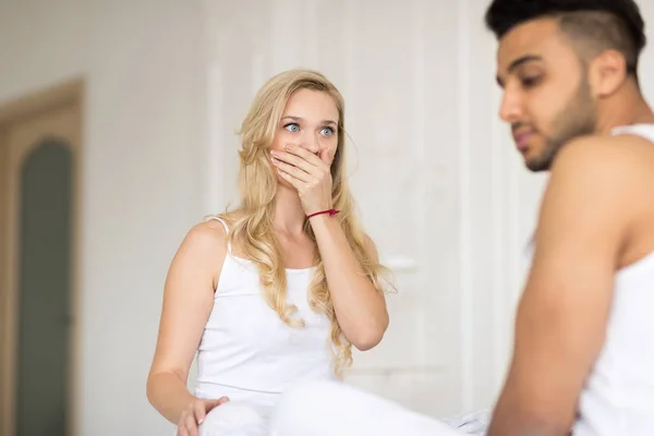 Pareja joven acostada en la cama, teniendo un problema de relaciones conflictivas, emociones negativas tristes Hombre y mujer hispanos infelices —  Fotos de Stock