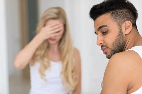 Pareja joven acostada en la cama, teniendo un problema de relaciones conflictivas, emociones negativas tristes Hombre y mujer hispanos infelices —  Fotos de Stock