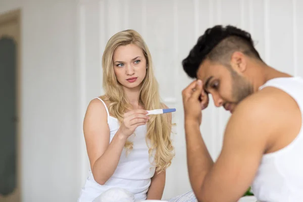 Jong koppel zitten In Bed, vrouw Toon Man positieve zwangerschapstest Conflict relaties probleem — Stockfoto