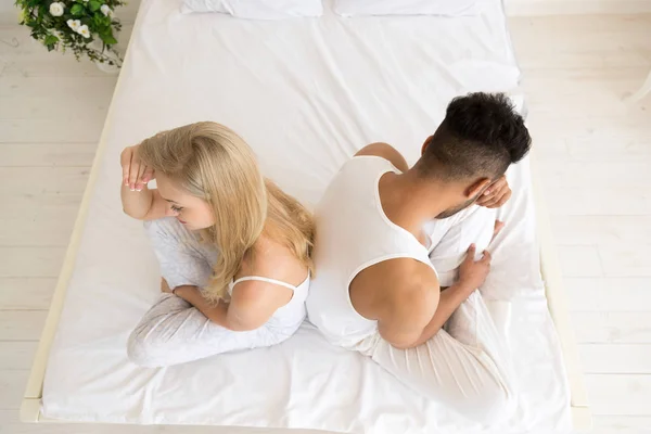 Pareja joven sentada en la cama, teniendo un problema de relaciones conflictivas, emociones negativas tristes Hombre y mujer hispanos — Foto de Stock