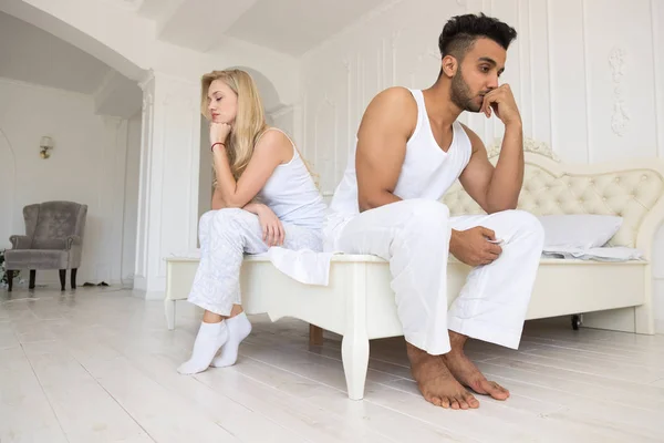 Молода пара сидить окремо на ліжку, маючи проблеми конфліктних відносин, сумні негативні емоції Іспанська чоловік і жінка — стокове фото
