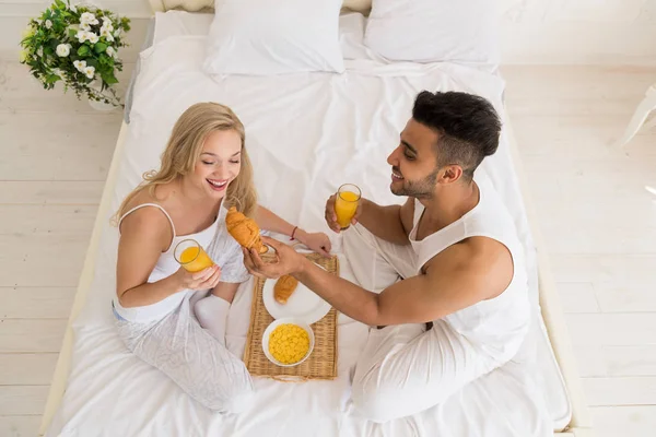 Jong (echt) paar ontbijt zitten In Bed, Happy glimlach Spaanse Man en vrouw ochtend Top hoekmening — Stockfoto