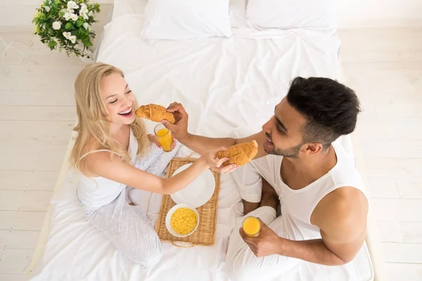 年轻夫妇早餐坐在床上, 快乐的微笑拉美裔男子和妇女早晨顶角视图 — 图库照片