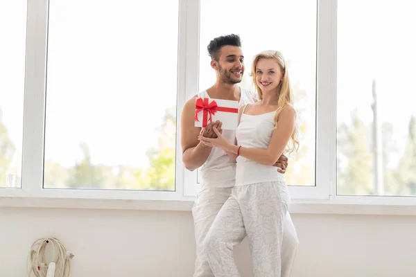 Young Beautiful Couple Stand Near Window Embrace Hold Present Envelope, Happy Smile Hispanic Man And Woman — Stock Photo, Image